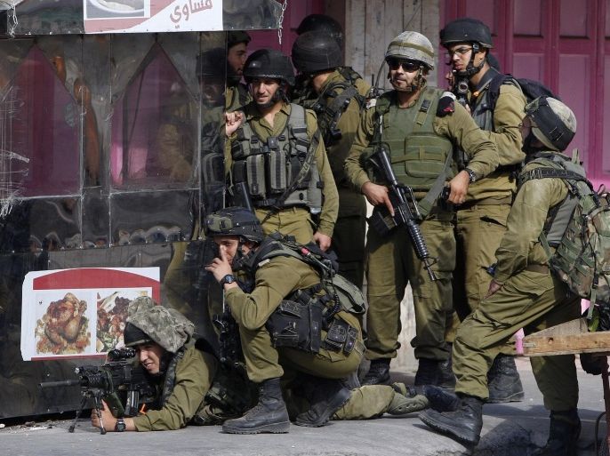 Israeli soldiers take up position during clashes with Palestinian stone throwers in the West Bank city of Hebron September 22, 2013.