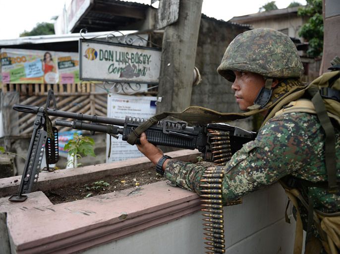 Philippine marine stands guard along a street as they look for other suspected rebels who clashed with policemen at a check point in Zamboanga City on the southern island of Mindanao on September 11, 2013, as the stand-off between government troops and Muslim gunmen enters its third day. Thousands of residents fled as fighting between Philippine troops and Muslim rebels intensified on September 11, the third day of a deadly siege in a key southern city. AFP