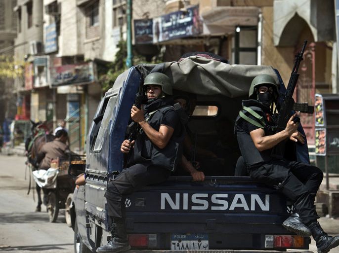 Egyptian armed policemen sit at the back of a truck as they patrol the village of Kerdassah in the district of Giza, on the outskirts of Cairo, on September 19, 2013. A police general was killed when Egyptian security forces stormed Kerdassah in the latest crackdown on Islamist militants, security officials said. AFP PHOTO / KHALED DESOUKI
