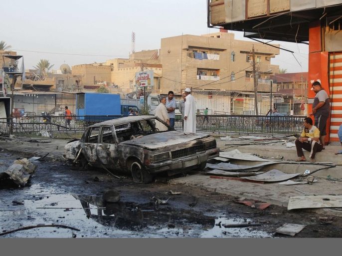 People gather at the site a day after a bomb attack in Baghdad, September 16, 2013. A wave of car bombs and shootings across Iraq killed at least 36 people on Sunday, police sources said.
