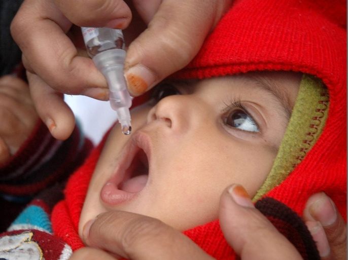 A volunteer administers pulse polio drops to a child at a booth in Bhopal, India, 20 January 2013. Children between the ages of zero and five years old are to be given pulse polio drops in a state campaign to get rid of the disease.