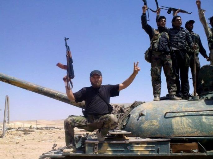 In this citizen journalism image provided by The Committee of Jabal al-Zawiyah, Jisr el-Sheghour, Maarat al-Naaman, Idlib, which has been authenticated based on its contents and other AP reporting, Free Syrian army fighters hold their weapons as they stand on a military tank in Idlib province, Syria, Wednesday, Sept. 4, 2013.
