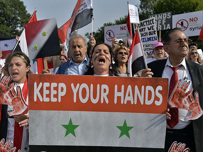 Supporters of Syrian President Bashar Al-Assad take part in a demonstration in front of the White House in Washington, DC, on September 9, 2013 urging US not to attack Syria. US Presidents Barack Obama and Bashar Al-Assad will go head-to-head in dueling US television interviews Monday, as a crucial week dawns for the US leader's push for air attacks on Syria. Assad denied that he used chemical weapons on civilians, as Obama makes a long-odds push to reverse his nation's mood and win support for punishing the Damascus regime for flouting taboos on the use of such arms. AFP Photo/Jewel Samad