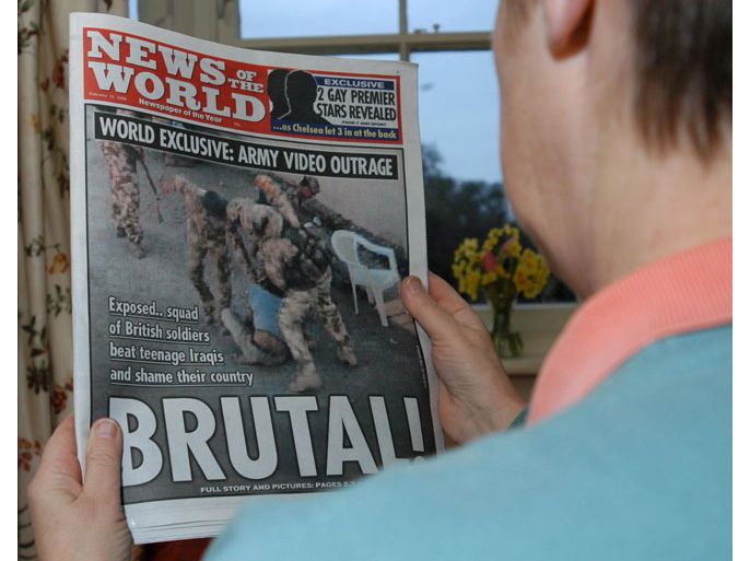 A reader holds a copy of the News of the World newspaper front page exclusive story published in Britain on Sunday 12 February 2006, exposing British soldiers beating teenage Iraqis. The images of the beating were apparently taken on a soldier's home video. EPA/NIGEL ISKANDER UNITED KINGDOM AND IRELAND OUT-