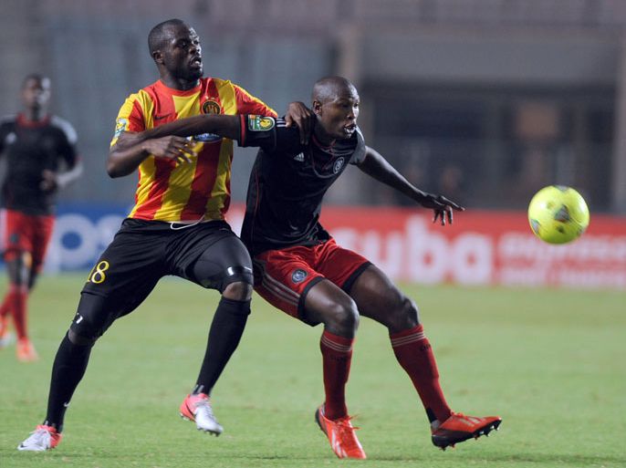 South Africa's Orlando Pirates defender Oscar Gcaba (R) vies with Esperance of Tunis striker Yannick Ndjeng (L) during the CAF Champions League semifinal football match between South African Orlando Pirates and Esperance of Tunis, at the Olympic Stadium in Rades, near Tunis, on October 19, 2013. South African club Orlando Pirates reached the CAF Champions League final after an 18-year absence by holding Esperance 1-1 in Tunisia. AFP PHOTO/ FETHI BELAID