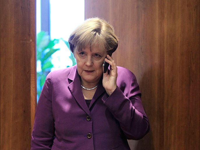 Germany's Chancellor Angela Merkel uses her mobile phone before a meeting at a European Union summit in Brussels in this December 9, 2011 file photograph. U.S. President Barack Obama on October 23, 2013 sought to assure German Chancellor Angela Merkel that the United States is not monitoring her communications after Merkel raised the issue with Obama. REUTERS/Yves Herman/Files (BELGIUM - Tags: POLITICS)