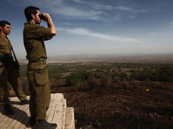 epa03458911 Israeli soldiers watching the Syrian side of the border from a military site, near the Israeli village of Alonie Habashan, in the center of the Golan Heights, on 05 November 2012. The Israeli army is on high alert level in the area, two days after three Syrian tanks T-55, penetrated the demilitarized area into the Syrian village of Bir Ajam, about 45 KM south of Damascus. EPA/ATEF SAFADI
