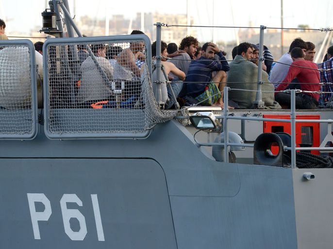 MLT48 - VALLETTA, -, MALTA : Migrants sit aboard a patrol boat of the Armed forces of Malta as they arrive at Hay Wharf in Valletta on October 12, 2013. More than 140 survivors, plucked from the sea after their overloaded boat sank in the latest deadly migrant tragedy to hit the Mediterranean, arrived in Malta. The sinking killed more than 30, most of them women and children, when the boat packed with people desperate to reach European shores went down off Malta near the Italian island of Lampedusa, according to officials. AFP PHOTO/MATTHEW MIRABELLI