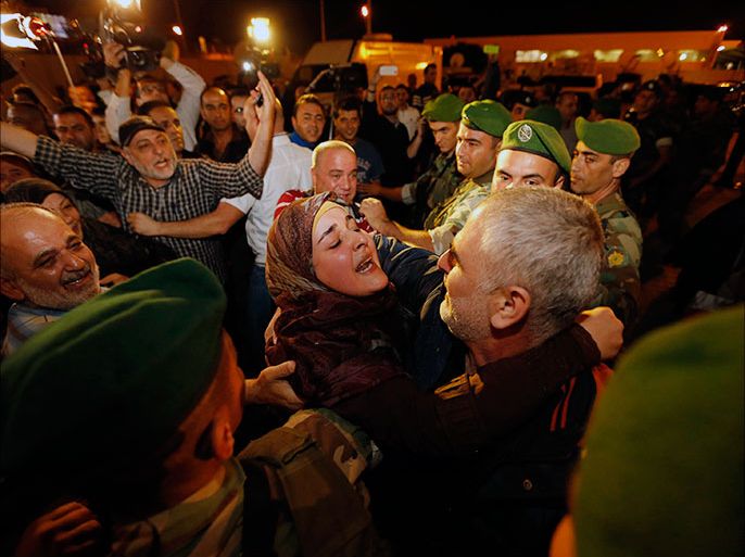 A female relative embraces one of the nine newly released Lebanese hostages, who were held by rebels in northern Syria, upon their arrival at Beirut international airport, October 19, 2013. A plane with nine Lebanese hostages freed from northern Syria landed safely in Beirut on Saturday night, witnesses said, nearly a year and a half after the men were captured by Syrian rebels near the Turkish border. REUTERS/Mohamed Azakir (LEBANON - Tags: POLITICS CIVIL UNREST TPX IMAGES OF THE DAY)