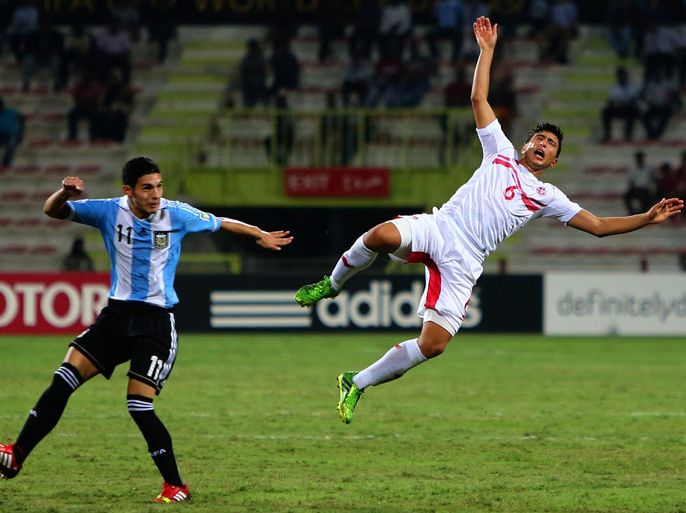 Marcos Astina (L) of Argentina vies for the ball against Wassim Naghmouchi of Tunisia during their round 16 of the FIFA U-17 World Cup football match at the Rashid Stadium in Dubai, on October 29, 2013. Argentina won the match 3-1. AFP PHOTO/MARWAN NAAMANI