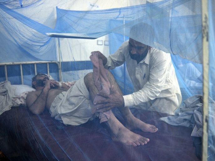 This photograph taken on September 23, 2013 shows a relative assisting a dengue fever patient at a hospital in Mingora, the capital of Swat Valley. The dengue epidemic, which began in late August in Pakistan's Swat Valley (northwest), has killed at least 23 people with more than 6,500 cases reported, according to a report provided by the local authorities. Dengue fever is spread by mosquitoes that breed in stagnant water and causes flu-like symptoms accompanied by nausea and sometimes bleeding, but is rarely fatal.