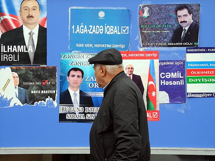 A man walks past a board plastered with campaign posters of presidential contenders in Baku, the capital of Azerbaijan, on October 7, 2013, ahead of the upcoming presidential elections