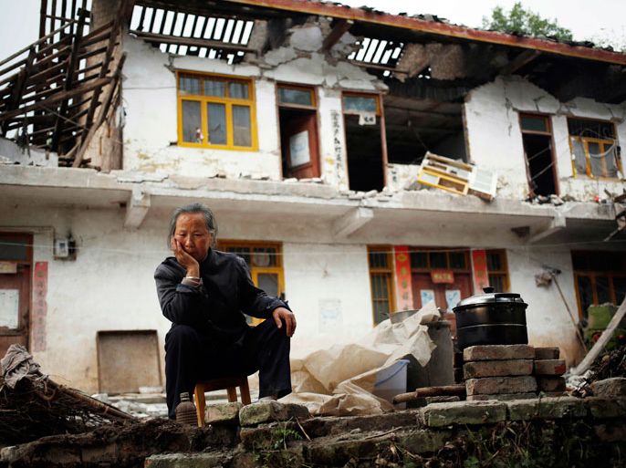 Chinese resident Ri Chenfu sits outside her home damaged by the earthquake in Ya'an, Sichuan Province, China, 21 April 2013. The death toll in the aftermath of a powerful earthquake in south-western China stood at more than 200 on 21 April, as search teams combed remote areas isolated by landslides, state media reported. At least 6,700 people were injured when earthquake struck Sichuan province at 8:02 am, state media said. The China Earthquake Administration (CEA) recorded a magnitude 7.0 earthquake, while the US Geological Survey said it had measured 6.9. EPA/HOW HWEE YOUNG