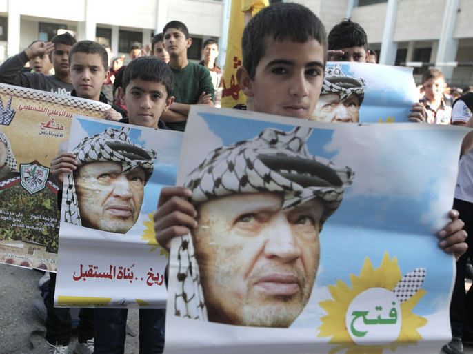 NABLUS, WEST BANK, - : Palestinian school boys hold posters of the late Palestinian leader Yasser Arafat as they mark the ninth anniversary of his death in the West Bank village of Salem just east of the city of Nablus on November 11, 2013. Arafat died in Paris on November 11, 2004 at 75 after falling sick a month earlier. Doctors were unable to specify the cause of death and no post-mortem was carried out at the time. AFP PHOTO/JAAFAR ASHTIYEH