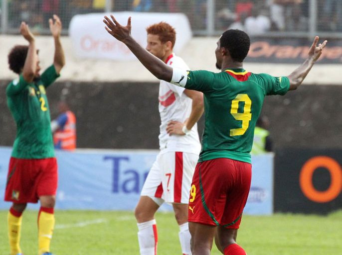 Cameroon's forward Samuel Eto'o (R) and defender Benoit Assou-Ekotto (L) celebrate qualifying for the 2014 FIFA World Cup in Brazil next to Tunisia's forward Fakhreddine Ben Youssef (C) after winning the second leg qualifying football match between Cameroon and Tunisia on November 17, 2013 in Yaounde. Cameroon won 4-1. AFP PHOTO / HOSNI MANOUBI
