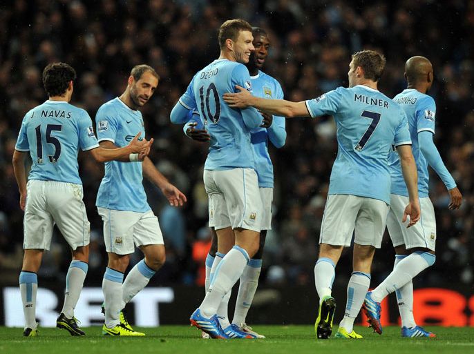 Manchester City's Bosnian striker Edin Dzeko (C) celebrates with teammates after scoring their fifth goal during the English Premier League football match between Manchester City and Norwich City at the Etihad Stadium in Manchester, northwest England, on November 2, 2013. Manchester City won the game 7-0. AFP PHOTO / PAUL ELLIS