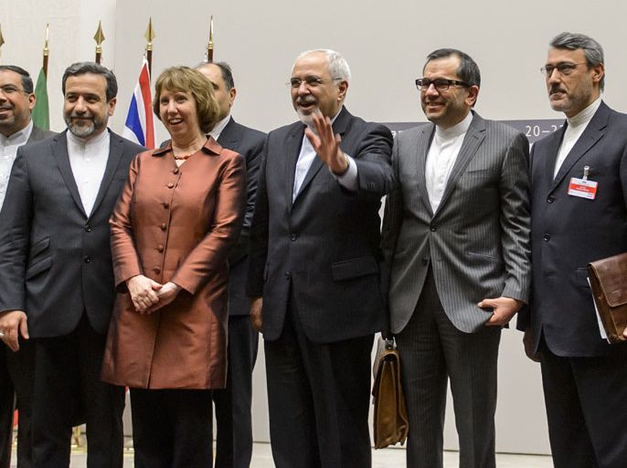 FAB269 - Geneva, Genève, SWITZERLAND : EU foreign policy chief Catherine Ashton (3rd L) poses next to Iranian Foreign Minister Mohammad Javad Zarif and the Iranian delegation after a statement on early November 24, 2013 in Geneva. World powers on November 24 agreed a landmark deal with Iran halting parts of its nuclear programme in what US President Barack Obama called "an important first step". According to details of the accord agreed in Geneva provided by the White House, Iran has committed to halt uranium enrichment above purities of five percent. AFP PHOTO / FABRICE COFFRINI