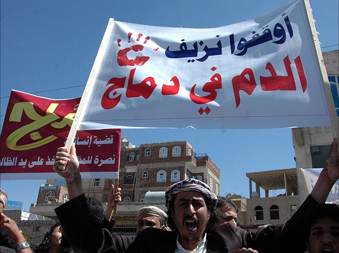 epa03931389 A Yemeni man holds up a banner with a slogan in Arabic reading: 'Stop the bloodshed in Dammaj' during a protest against fighting between the Shiite Houthi movement and Salafi militants in the northern town of Dammaj, in Sana'a, Yemen, 31 October 2013