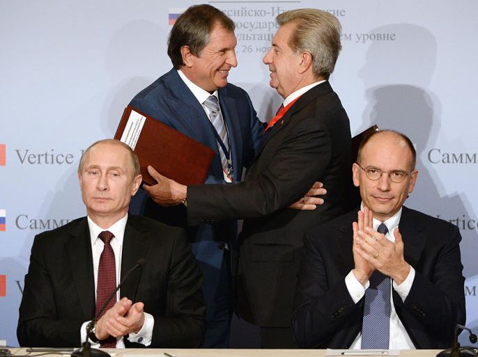 epa03966319 Russian President Vladimir Putin (seated L) and Italian Prime Minister Enrico Letta (seated R) applaud as as the CEO of Enel, Fulvio Conti (R) hugs the Chairman of Rosneft Igor Sechin (L) after a signing ceremony during their meeting in Trieste, Italy, 26 November 2013. A total of 21 trade and business deals will be signed at the summit in the northern Italian city of Trieste on 26 November 2013, where Premier Enrico Letta will meet Russian President President Vladimir Putin, and at a related forum. The deals span from the finance sector to the fields of energy and industry. They feature deals between Italian energy companies ENEL and ENI and Russia's Rosneft. EPA/DANIEL DAL ZENNARO EPA/DANIEL DAL ZENNARO