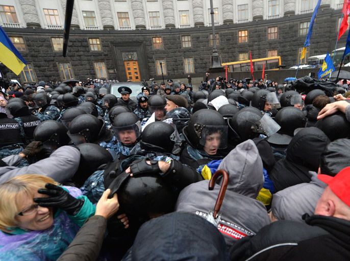 Kiev, -, UKRAINE : Activists clash with riot police in front of the Ukrainian Cabinet of the Ministers during a protest in Kiev on November 25, 2013. Pro-West Ukrainians staged the biggest protest in Kiev since the 2004 Orange Revolution, demanding that the government sign a key pact with the European Union. The opposition called the rally after President Viktor Yanukovych's government reversed a plan to sign a historic deal deepening ties with the European Union, in a U-turn critics said was forced by the Kremlin. AFP PHOTO/ SERGEI SUPINSKY
