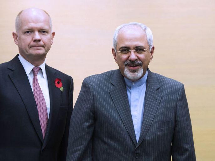 JIR12 - Geneva, Genève, SWITZERLAND : Iranian Foreign Minister Mohammad Javad Zarif (R) pose with British Foreign Secretary William Hague (L), on November 9, 2013, on the third day of talks on Iran's nuclear programme at the Intercontinental Hotel in Geneva Switzerland. Crunch talks between Iran and world powers stretched into an unscheduled third day on November 9 as top diplomats pushed for a deal to end the decade-old standoff over Iran's nuclear programme. AFP PHOTO / POOL / JEAN-CHRISTOPHE BOTT