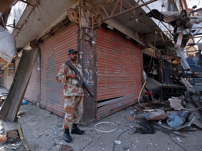 A paramilitary soldier guards the site of Friday night's bomb blast in Karachi November 23, 2013. Two blasts, following in quick succession