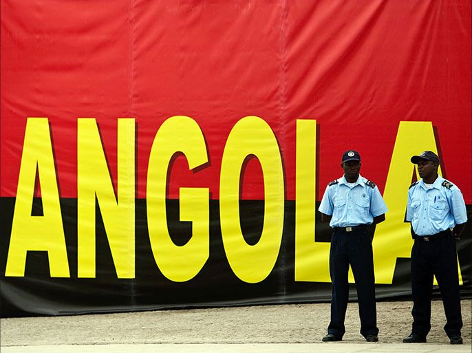 epa03372340 Policemen stand in front of a flag with 'Angola' written on it during the inauguration of the new Marginal of the Luanda Bay held by the MPLA candidate for the presidency of Angola Jose Eduardo dos Santos (not pictured), in Luanda, Angola, 28 August 2012. Angola will hold general elections on August 31, which will define the composition of parliament and the names of the President and Vice President of the Republic. EPA/PAULO NOVAIS