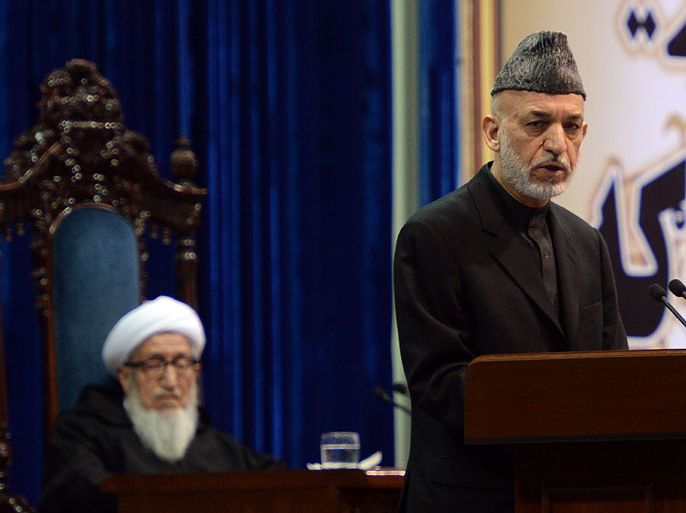 Kabul, -, AFGHANISTAN : Afghan president Hamid Karzai (R) speaks as the head of the loya jirga Sebghatullah Mujaddidi (L) listens during the first day of a four-day long loya jirga, a meeting of around 2,500 Afghan tribal elders and leaders in Kabul, on November 21, 2013. Up to 15,000 foreign troops could stay in Afghanistan beyond 2014 if a security pact with the US is signed, President Hamid Karzai said. About 2,500 tribal chiefs, chieftains and dignitaries are gathered in Kabul for a discussion of the bilateral security agreement with the US. AFP PHOTO/Massoud HOSSAINI