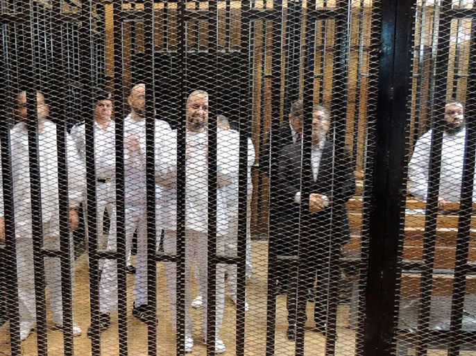 epa03935928 A photo released by the Egyptian interior ministry showing ousted president Mohamed Morsi (2-R) standing behind bars with other unidentified Muslim Brotherhood defendants during first trial session, in Cairo, Egypt, 04 November 2013. An Egyptian judge on 04 November adjourned until 08 January 2014 the trial of toppled Islamist leader Mohamed Morsi, who told the court at the chaotic start of his trial that he was the legitimate president. EPA/INTERIOR MINISTRY HANDOUT BEST QUALITY AVAILABLE HANDOUT EDITORIAL USE ONLY/NO SALES