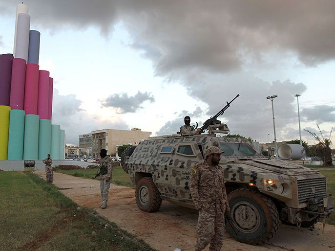 Libyan security members stand by an armored personnel carrier as they patrol the streets of Benghazi, the cradle of the Libyan revolution, on November 14, 2013.