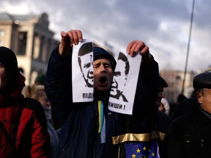A protester tears a portrait of Ukraine's President Viktor Yanukovich during a demonstration in support of the EU integration at Independence Square in Kiev November 29, 2013. Ukraine's President Viktor Yanukovich failed on Thursday to salvage an ambitious free-trade pact with the European Union despite a warning that Ukraine was risking its future by turning its back on the deal. Ukraine and the 28-nation EU had aimed to sign an ambitious trade and cooperation agreement at Thursday's summit in the Lithuanian capital Vilnius