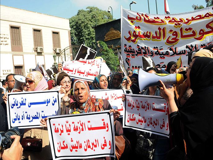 epa03948086 Egyptian women hold Arabic banners calling for women parliamentary quota in the new country's constitution during a protest in front of the Shura Council, in Cairo, Egypt, 13 November 2013. Media reports state dozens of women gathered outside the Shura Council to demand a women parliamentary quota in the amended constitution. An Egyptian constitutional panel is currently amending the constitution backed by Islamists last year. EPA/AHMED ASSADI