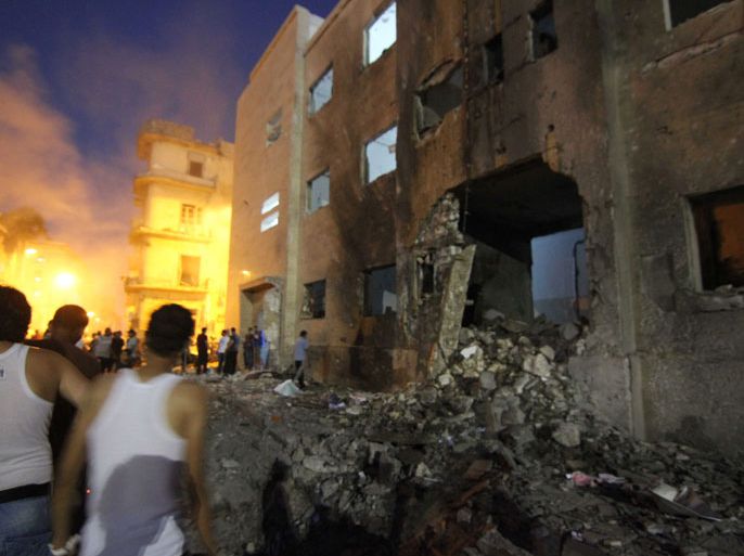 People gather in the street after a bomb, planted by unknown attackers, exploded outside the north courthouse in Benghazi, Libya, 28 July 2013. Initial reports state that ten people were injured in the blast and have been taken to