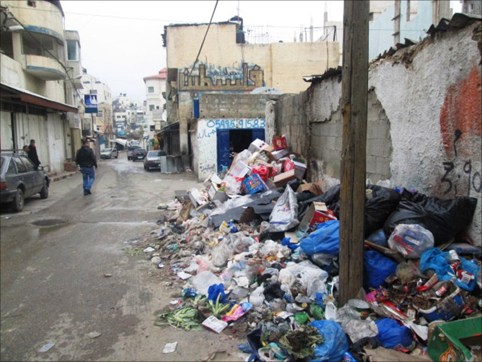 أكوام النفايات في مخيم الأمعري بسبب إضراب عمال الوكالة (الجزيرة)