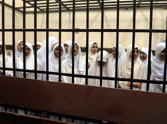A photo made available on 28 November 2013 shows female Islamist demonstrators standing behind bars during a trial session at a court in Alexandria, Egypt, 27 November 2013. Media reports state an Egyptian court on 27 November handed down 11-year sentences to 21 female Islamist demonstrators, who were arrested after an early morning demonstration in the coastal city. Seven of the defendants are minors and will be sent to a juvenile home, while the remainders were jailed. EPA/MAHMOUD TAHA/ALMASRY ALYOUM EGYPT OUT