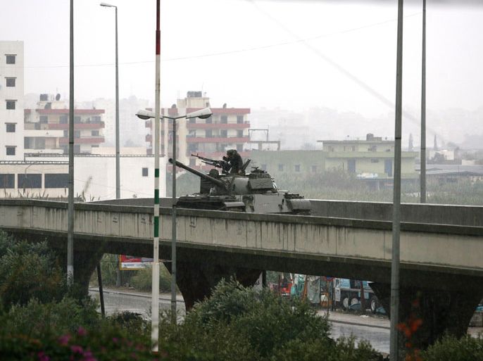 Lebanese army soldiers keep watch from their tank stationed on a bridge in the northern Lebanese city of Tripoli on December 3, 2013 as army began deploying following a week of clashes between supporters and opponents of the Syrian regime. Lebanese authorities decided to place Tripoli under army control for six months after a wave of sectarian killings linked to Syria's war left 11 dead in the main northern city. AFP PHOTO/GHASSAN SWEIDAN