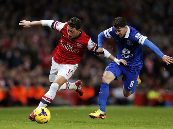 Arsenal's German midfielder Mesut Ozil (L) vies for the ball against Everton's Costa Rican midfielder Bryan Oviedo (R) during the English Premier League football match between Arsenal and Everton at The Emirates Stadium in north London on December 8, 2013. AFP PHOTO/ADRIAN DENNIS