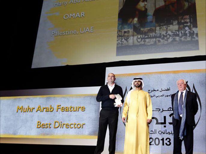 KS1399 - Dubai, -, UNITED ARAB EMIRATES : Director Hany Abu-Assad (L) is presented by Sheikh Mansour (C), son of Dubai ruler Sheikh Mohammed bin Rashid al-Maktoum, with the award of Muhr Arab Feature award (Best director) for his film "Omar" during the Dubai International Film Festival (DIFF) in Dubai on December 13, 2013. AFP PHOTO / KARIM SAHIB