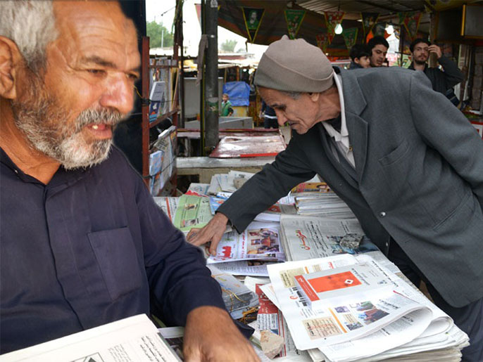 ناصر سالم (يسار) أقدم صاحب مكتبة على الرصيف في البصرة (الجزيرة)