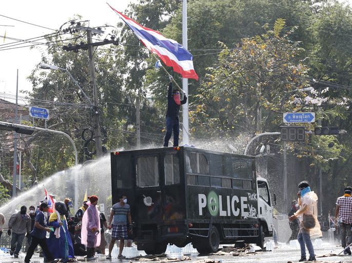 epa03973716 Thai anti-government protesters commander a police truck and taunt police at Government House as street battles for control of the seat of government continue in Bangkok, Thailand, 02 December 2013. Thousands of protesters vowed to take control of government ministries and offices including the seat of Government House in an effort to oust the government of Prime Minister Yingluck Shinawatra and its defacto leader from afar her brother Thaksin Shinawatra. EPA