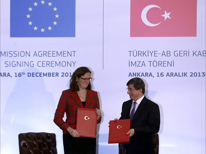 Turkish Foreign Affairs Minister Ahmet Davutoglu (R) poses with EU Home Affairs Commissioner Cecilia Malmstrom after signing the Visa Liberation Dialogue Agreement during the Turkey-EU readmission agreement signing ceremony in Ankara on December 16, 2013. Turkey signed a long-awaited deal with the European Union on December 16 to send back people who enter the bloc illegally from its territory in exchange for talks on visa-free travel for its citizens. The move, hailed as a "milestone" in EU-Turkish relations, comes six weeks