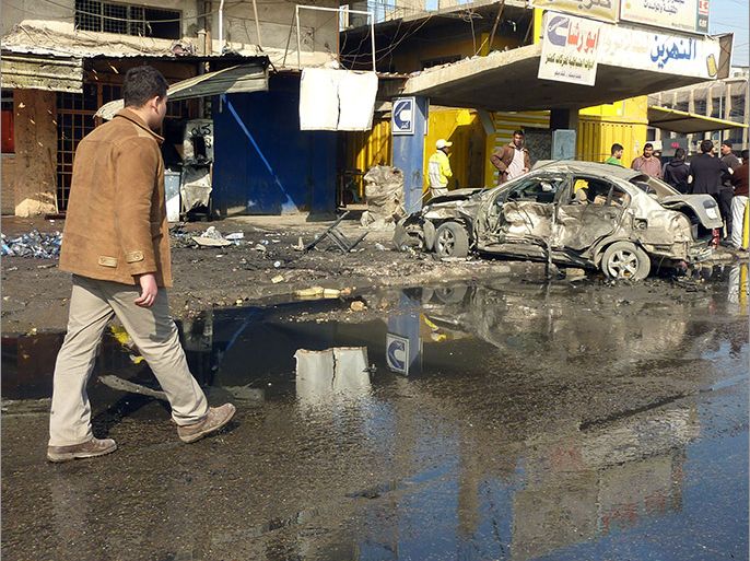 Baghdad, -, IRAQ : An Iraqi man walks past the site of a car bomb in central Baghdad, on January 15, 2014. Attacks in and north of the capital including a suicide bombing at a funeral and seven car bombs, which killed at least 39 people officials said. AFP PHOTO/ALI AL-SAADI
