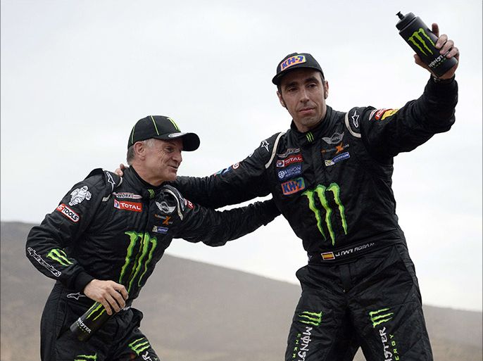 Mini driver Nani Joan Roma (R) of Spain and co-driver Michel Perin celebrate their victory after the 13th stage of the Dakar 2014, between La Serena and Valparaiso, Chile on January 18, 2014. Spain’s Nani Roma won the Dakar Rally 2014 ahead of France's Stephane Peterhansel and Nasser Al-Attiyah of Qatar. AFP PHOTO / FRANCK FIFE
