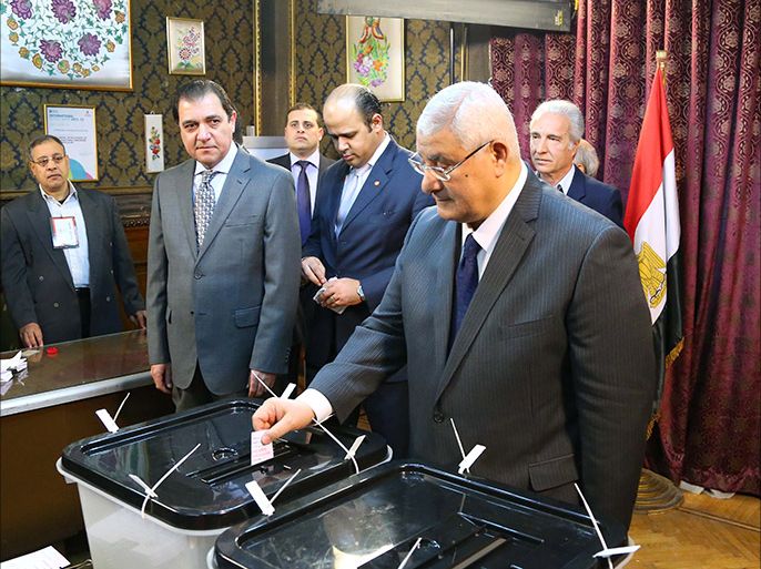 A handout picture released by Egyptian presidency shows Egypt’s interim president Adly Mansour casting his vote on a new constitution at a polling station in Cairo on January 14, 2014. Egyptians were voting amid high security in a referendum likely to launch a presidential bid by the army chief who overthrew Islamist president Mohamed Morsi. AFP PHOTO / EGYPTIAN PRESIDENCY