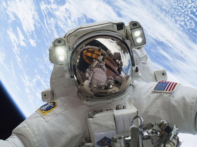 Astronaut Mike Hopkins, Expedition 38 Flight Engineer, is shown in this handout photo provided by NASA as he participates in the second of two spacewalks which took place on December 24, 2013, released on December 27, 2013. The scheduled spacewalks were designed to allow the crew to change out a faulty water pump on the exterior of the Earth-orbiting International Space Station. He was joined on both spacewalks by NASA astronaut Rick Mastracchio, whose image shows up in Hopkins' helmet visor. REUTERS/NASA/Handout via Reuters (UNITED STATES - Tags: SCIENCE TECHNOLOGY TPX IMAGES OF THE DAY) ATTENTION EDITORS - THIS IMAGE WAS PROVIDED BY A THIRD PARTY. FOR EDITORIAL USE ONLY. NOT FOR SALE FOR MARKETING OR ADVERTISING CAMPAIGNS. THIS PICTURE IS DISTRIBUTED EXACTLY AS RECEIVED BY REUTERS, AS A SERVICE TO CLIENTS