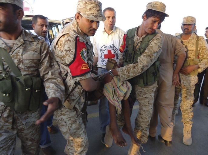 Army personnel and Red Cross medics carry a wounded man during an evacuation of injured people from Dammaj, in Yemen's northwestern province of Saada January 6, 2014. The International Committee of the Red Cross (ICRC) on Sunday evacuated 35 people wounded in the fighting between Salafists and Shi'ite Houthis in Dammaj, the relief agency said in a statement. REUTERS/Stringer (YEMEN - Tags: POLITICS CIVIL UNREST)