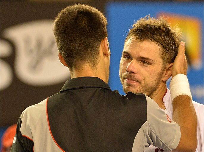 Switzerland's Stanislas Wawrinka (R) hugs Serbia's Novak Djokovic after winning their men's singles match on day nine at the 2014 Australian Open tennis tournament in Melbourne on January 21, 2014. IMAGE RESTRICTED TO EDITORIAL USE - STRICTLY NO COMMERCIAL USE AFP PHOTO / PAUL CROCK