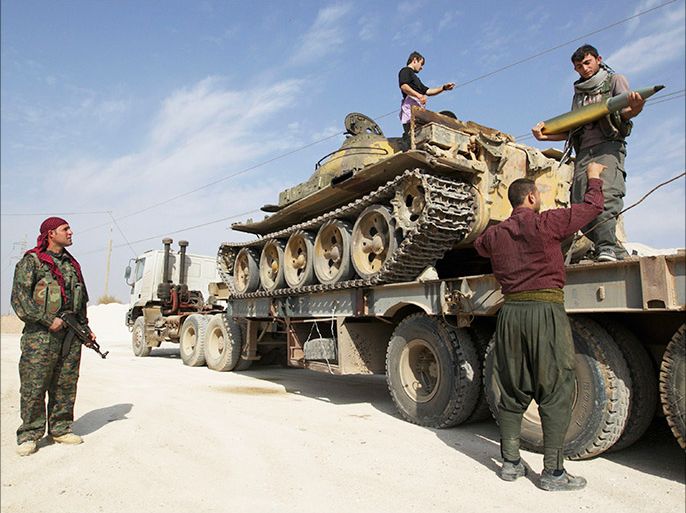 Members of Kurdish People's Protection Units (YPG) are seen on a military truck that belonged to the Islamist rebels after capturing it near Ras al-Ain, in this November 6, 2013 file photo. REUTERS/Stringer/Files (SYRIA - Tags: POLITICS CIVIL UNREST MILITARY)