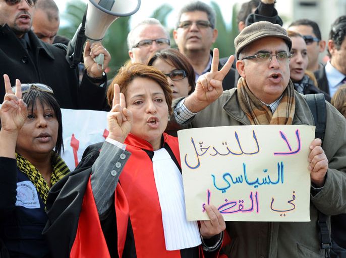 Tunisian General Secretary of the National Union of Magistrates Raoudha Labidi (C) shouts slogans as she holds a sign that reads in Arabic, " No to political interference in the judiciary" during a demonstration by judges to protest against a law that will be adopted by the Constituent Assembly on January 15, 2014 in Tunis. Tunisians marked the third anniversary on January 14 of the ending of years of dictatorship in the first Arab Spring uprising but political bickering prevented adoption of a new constitution by the symbolic target date. AFP