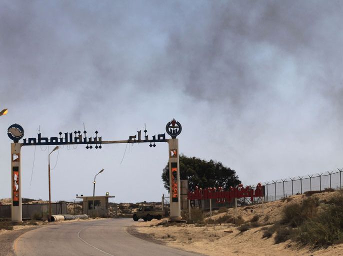 The entrance to Zueitina oil terminal is seen in Zueitina, about 120 km (75 miles) west of Benghazi July 18, 2013. Almost every week, Prime Minister Ali Zeidan either tries to cajole the fighters choking off Libya's crude exports or threatens to break their blockade by force. Neither tactic has worked. Their leader, Ibrahim al-Jathran, dug in at ports his men seized in August 2013, says he will sell Libya's oil himself and carve out a semi-state unless the eastern region gets a fairer share of the revenues. The mutiny, which has shut three ports accounting for around half the OPEC member's exports, has helped send global crude prices up and they could rise much further if any armed clash inflicts long term damage. But lawmakers, oil sources and diplomats say Zeidan and Jathran are not on the brink of war, and that if Zeidan can survive a political crisis in the capital he may win the upper hand in the war of attrition over oil exports. Picture taken July 18, 2013. REUTERS/Esam Omran Al-Fetori (LIBYA - Tags: BUSINESS CIVIL UNREST POLITICS ENERGY)